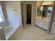 Bathroom featuring a soaking tub, and a vanity with double sinks and ample cabinet space at 6827 Neuhoff Ln, Charlotte, NC 28269