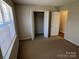 Bedroom with carpet flooring, large window for natural light and closet at 6827 Neuhoff Ln, Charlotte, NC 28269