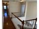 Hallway featuring wood floors, access to the stairs, and a neutral color palette throughout at 6827 Neuhoff Ln, Charlotte, NC 28269
