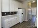A kitchen featuring white cabinets, sleek countertops, and stainless steel refrigerator at 6827 Neuhoff Ln, Charlotte, NC 28269