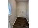 An empty laundry room with wood floors and a window at 6827 Neuhoff Ln, Charlotte, NC 28269