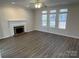 Spacious living room with a fireplace, hardwood floors, and plenty of natural light at 6827 Neuhoff Ln, Charlotte, NC 28269