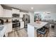 Well-lit kitchen with stainless steel appliances, a granite island with seating, and white cabinets flowing into the living space at 715 Bonica Ct, Lancaster, SC 29720