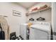 Well-organized laundry room with white washer and dryer, storage shelf, and laundry accessories at 715 Bonica Ct, Lancaster, SC 29720
