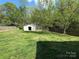 Fenced backyard with mature trees and a storage shed at 7939 Holly Hill Rd, Charlotte, NC 28227