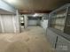 Unfinished basement featuring concrete floors, cinder block walls, and wooden support beams at 7939 Holly Hill Rd, Charlotte, NC 28227