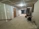 Unfinished basement featuring concrete floors, drywall, and stairwell access at 7939 Holly Hill Rd, Charlotte, NC 28227