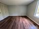 Bedroom with hardwood floors, bi-fold closet doors, and natural light at 7939 Holly Hill Rd, Charlotte, NC 28227