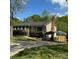 Home exterior with a carport, brick chimney, and lush green surroundings at 7939 Holly Hill Rd, Charlotte, NC 28227