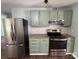 Updated kitchen with stainless steel appliances, stone countertops and light green cabinets at 7939 Holly Hill Rd, Charlotte, NC 28227