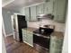 Modern kitchen featuring stainless steel appliances, granite countertops, and light green cabinets at 7939 Holly Hill Rd, Charlotte, NC 28227