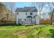 Backyard view of a two-story home with a wooden deck, fenced in yard, and green grass at 8733 Canter Post Dr, Charlotte, NC 28216