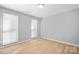 Empty bedroom with light gray walls, light wood flooring, and two windows at 8733 Canter Post Dr, Charlotte, NC 28216