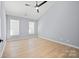 Bedroom with two windows allowing for natural light, ceiling fan, and wood floors at 8733 Canter Post Dr, Charlotte, NC 28216