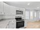 Bright kitchen with stainless steel appliances, white cabinetry, modern fixtures, and granite countertops at 8733 Canter Post Dr, Charlotte, NC 28216
