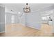 Open living space with hardwood floors, stylish lighting, and a view of the staircase and kitchen at 8733 Canter Post Dr, Charlotte, NC 28216