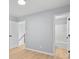Empty room with light gray walls, light wood flooring, and bathroom at 8733 Canter Post Dr, Charlotte, NC 28216