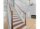 Stairway with wooden railing leading to a living room with fireplace at 8733 Canter Post Dr, Charlotte, NC 28216