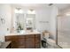 Bathroom features double vanity, framed mirrors, modern fixtures, and a glass-enclosed shower at 9740 Wardley Dr, Charlotte, NC 28215