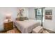 Cozy bedroom featuring a comfortable bed, side table, and charming floral artwork at 9740 Wardley Dr, Charlotte, NC 28215