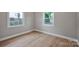 A bedroom featuring modern floors, neutral walls, and two large windows at 1008 Bose Ave, Rock Hill, SC 29732