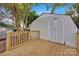 Backyard shed featuring double doors and a wooden deck with railing under a canopy of trees at 1008 Bose Ave, Rock Hill, SC 29732