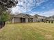 Rear view of a home showcasing a well-maintained lawn, screened porch, and exterior architecture at 10521 Ardley Manor Dr, Mint Hill, NC 28227