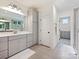 Bright bathroom featuring double sink vanity, linen closet and walk-in shower with glass surround at 10521 Ardley Manor Dr, Mint Hill, NC 28227
