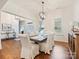 Dining room with hardwood floors, white chairs, modern light fixture, and natural light at 10521 Ardley Manor Dr, Mint Hill, NC 28227
