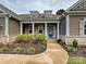 Inviting front entrance with a well-manicured garden, stone accents, and a covered porch at 10521 Ardley Manor Dr, Mint Hill, NC 28227