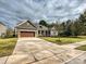 Charming front exterior of a home with a spacious driveway and well-maintained landscaping at 10521 Ardley Manor Dr, Mint Hill, NC 28227