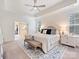 Bright main bedroom featuring tray ceilings, a ceiling fan, and access to an ensuite bath at 10521 Ardley Manor Dr, Mint Hill, NC 28227