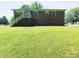 A brick two-story home features an expansive backyard with a set of stairs and white railing at 108 W Jefferson St, York, SC 29745