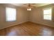 Bright bedroom with hardwood floors, ceiling fan, and natural light from two windows at 108 W Jefferson St, York, SC 29745
