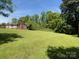 Expansive front yard showcases a charming brick home, surrounded by lush greenery at 108 W Jefferson St, York, SC 29745