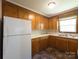 Well-lit kitchen with wooden cabinets and white appliances with tile floors at 108 W Jefferson St, York, SC 29745