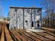 A view of the back of the house featuring a gray siding, a small patio, and a wooded backdrop at 112 Brook Creek Dr, Troutman, NC 28166