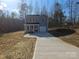 Charming two-story home featuring gray siding, a welcoming front porch, and an attached garage at 112 Brook Creek Dr, Troutman, NC 28166