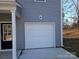 Exterior view of a two car garage showcasing gray siding and a gray door at 112 Brook Creek Dr, Troutman, NC 28166