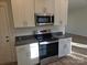 Close up of the kitchen featuring white cabinets, stainless steel appliances, granite countertops, and vinyl flooring at 112 Brook Creek Dr, Troutman, NC 28166