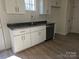 Well-lit kitchen features white cabinets, granite countertops, stainless steel dishwasher, and wood floors at 112 Brook Creek Dr, Troutman, NC 28166
