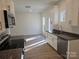 Open kitchen design boasting white cabinets, modern stainless steel appliances, granite countertops, and vinyl flooring at 112 Brook Creek Dr, Troutman, NC 28166