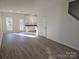 An open-concept area with white walls, vinyl flooring, and a view into the kitchen at 112 Brook Creek Dr, Troutman, NC 28166