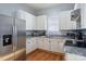 Well-equipped kitchen with stainless steel refrigerator, white cabinets, and granite countertops at 12 Church St, York, SC 29745