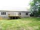 Expansive backyard features a wooden deck, with mature trees, and lush green lawn at 1202 Louise Ln, Albemarle, NC 28001