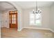 Bright dining room with wood floors, stylish chandelier, and view of the landscaped front yard at 1202 Louise Ln, Albemarle, NC 28001
