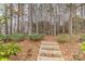 Backyard featuring a mulch path and wooden steps leading into the wooded area at 125 Whiterock Dr, Mount Holly, NC 28120