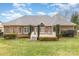 Brick home has a beautifully landscaped backyard with a white deck and stairs at 125 Whiterock Dr, Mount Holly, NC 28120