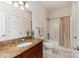 Bright bathroom features a granite vanity, tile floors, and shower-tub combo with curtain at 125 Whiterock Dr, Mount Holly, NC 28120