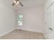 Bedroom with neutral decor features ceiling fan and window with backyard views at 125 Whiterock Dr, Mount Holly, NC 28120